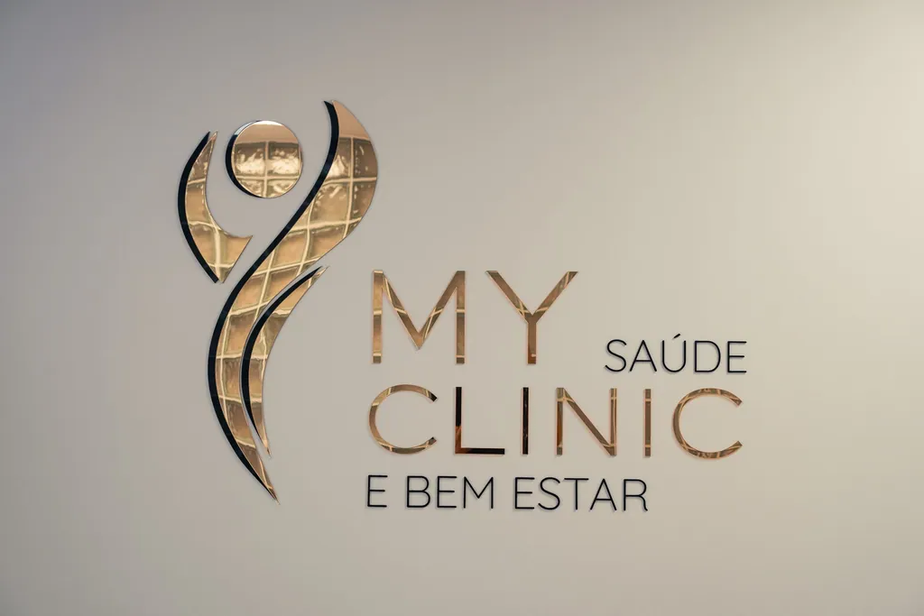 Logótipo MyClinic em relevo dourado na parede da receção