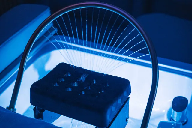 Marquesa de Head Spa iluminada a azul, com o arco de fios sobre o apoio da cabeça